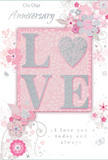 This anniversary card is a tender tribute to lasting romance, blending soft pastel pinks, pearly whites, and silvery greys into a design that feels as cherished as a favourite walk through Westcombe Park's tree-lined streets. At the centre, the word LOVE stands out in raised, softly rounded letters, generously dusted with fine glitter. The letter O is transformed into a shimmering heart, textured with silver sparkle that gives it a jewel-like presence, inviting fingers to pause and explore. Behind the lettering, the blush-pink background glows gently, like evening light filtering through sheer curtains. Around this focal point, an arrangement of delicate blossoms unfurls-flowers in shades of blush, mauve, and light ivory, their edges softened as though painted in watercolour. Fine, swirling lines suggest stems, tendrils, and graceful vines, bringing a sense of casual elegance, similar to the way a florist might let a few stems arc naturally from a hand-tied bouquet. Tiny decorative touches-scattered petals, subtle curls, and almost hidden butterflies-dance in the negative space, giving the design movement and a hint of whimsy. Above and below the floral display, the phrases On Our Anniversary and I love you today and always are written in an understated, flowing script, offering warmth without overwhelming the artwork. The card feels quietly celebratory, perfect for marking another year of shared memories, from cosy dinners at home to strolls down nearby streets. Its textures, colours, and motifs together create the impression of a soft-spoken yet deeply heartfelt keepsake for enduring love in Westcombe Park.